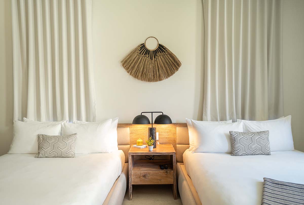 Two beds next to each other with a side table in the middle