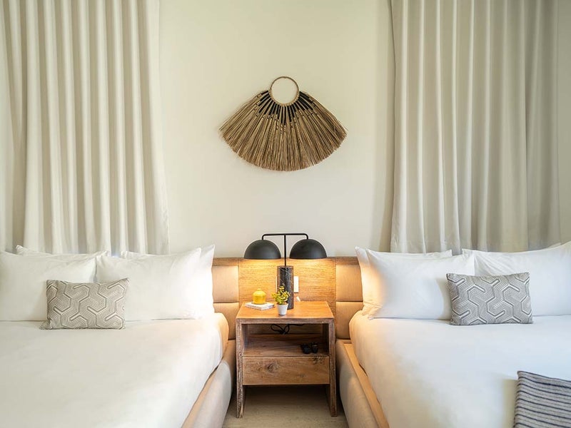 Two beds next to each other with a side table in the middle