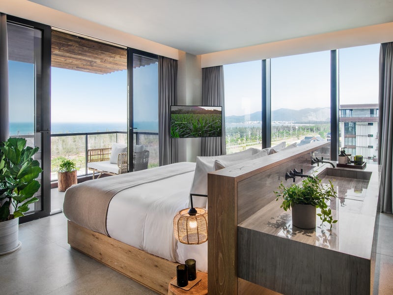 A bed with double sinks opposite the headboard