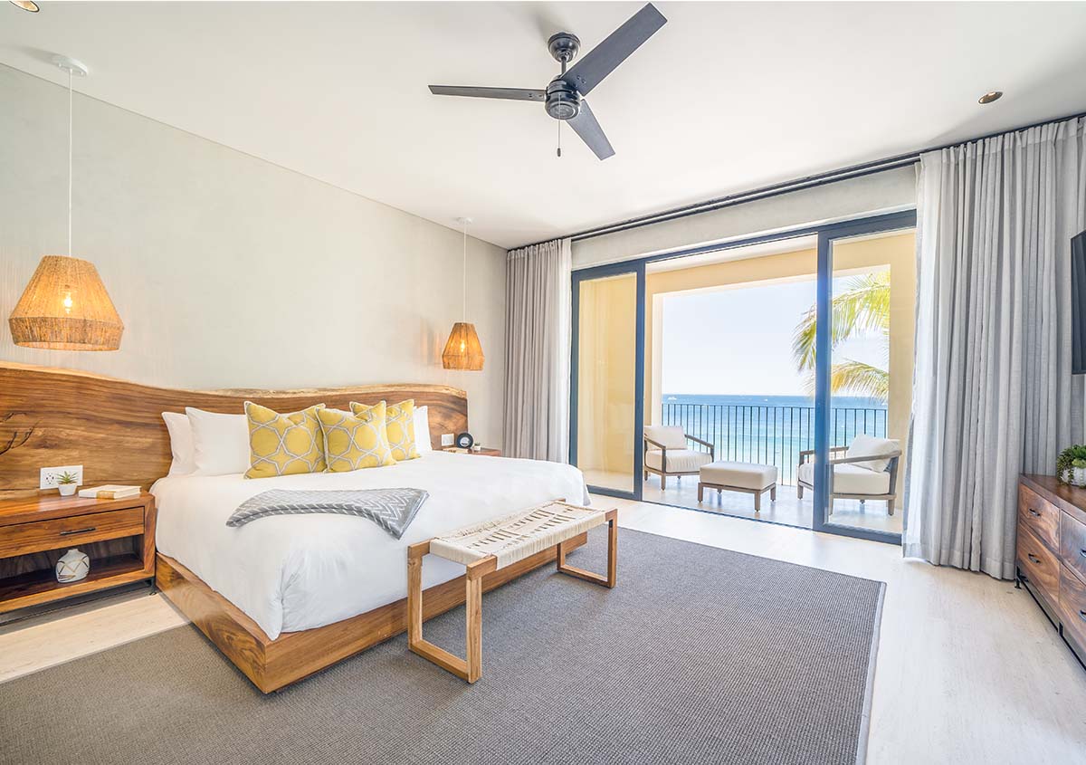 A made bed with a bench at the end 