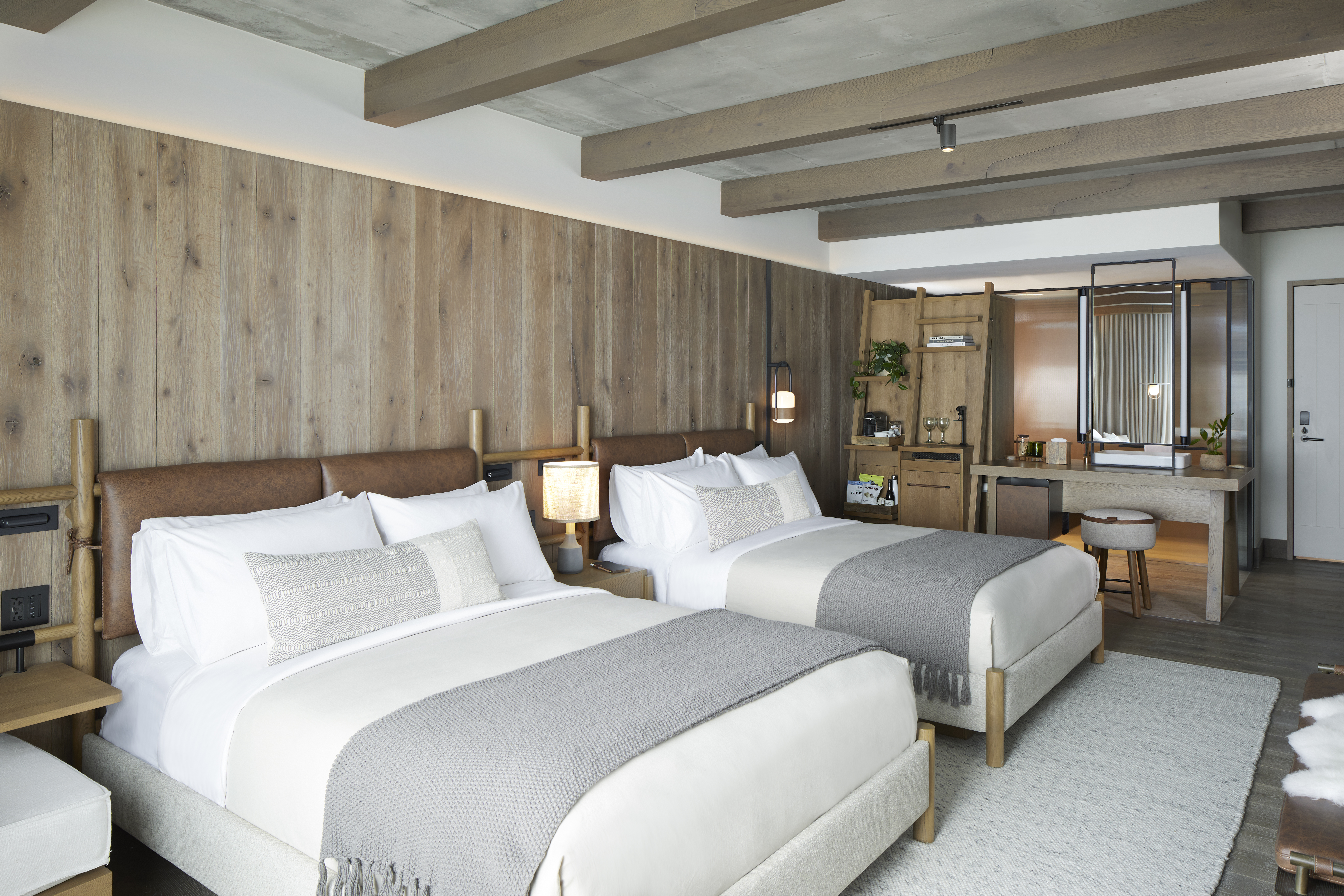 Wood paneled room with two made beds
