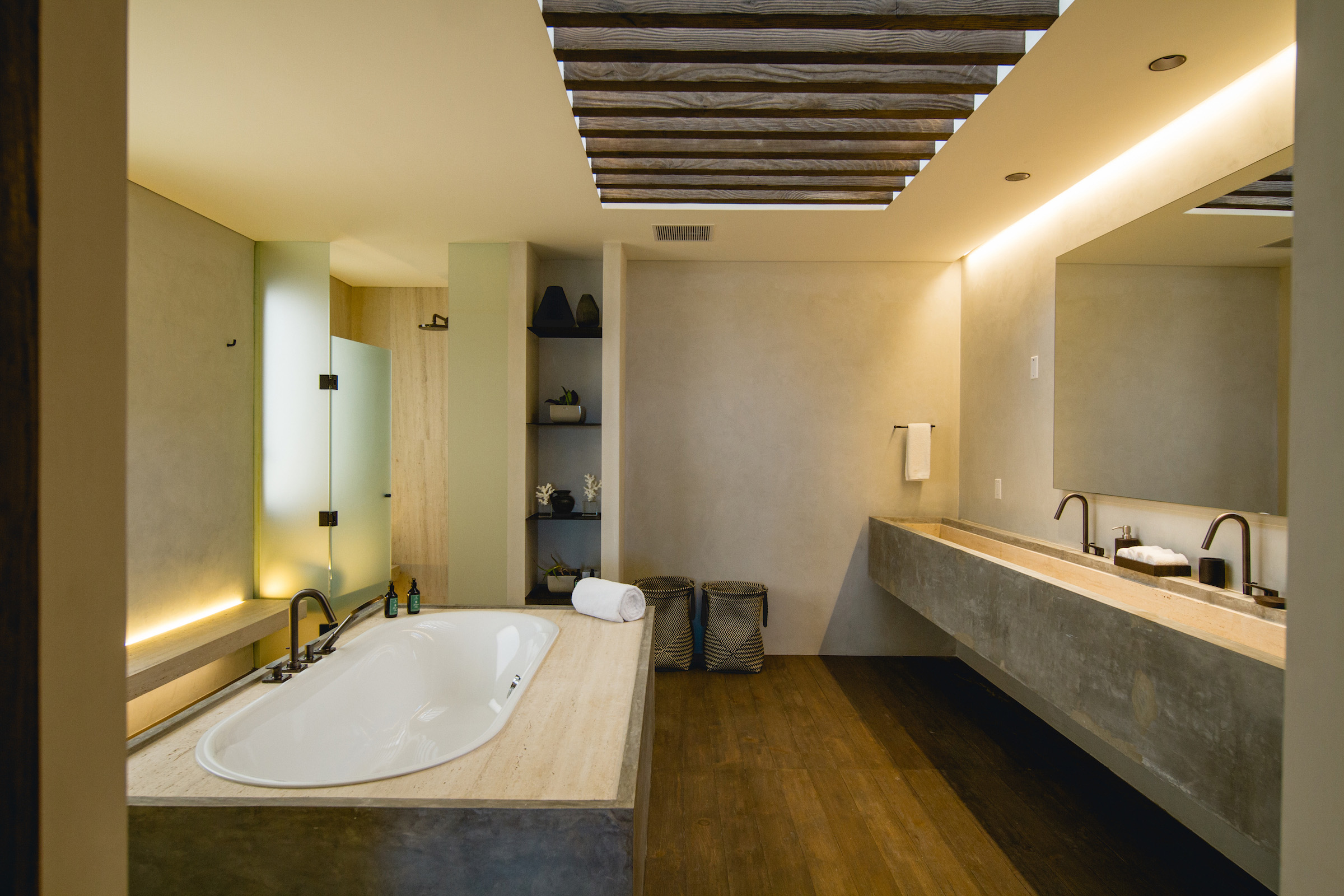 A bathroom with a long sink and large bathtub