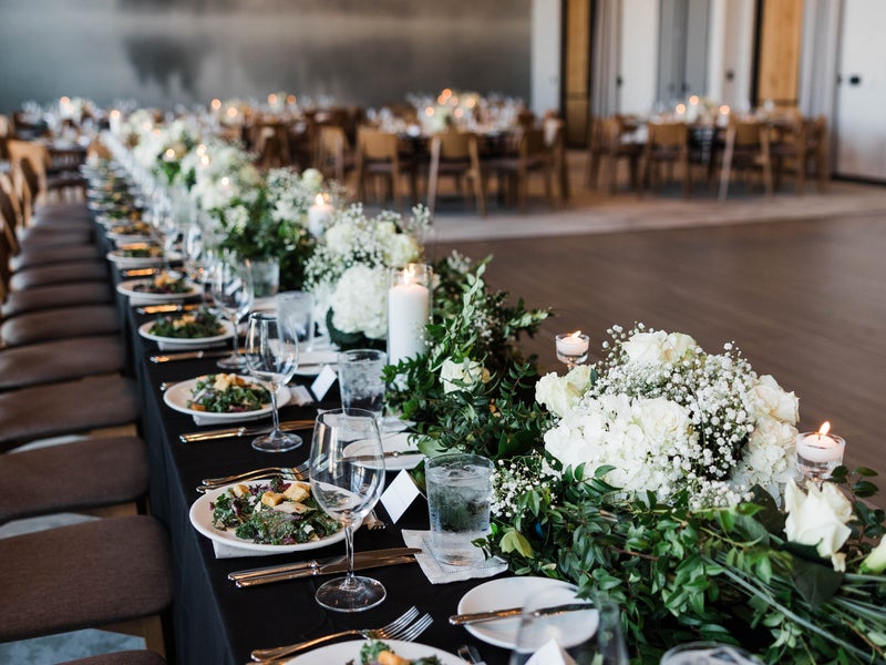 Long table set large flower centerpieces and plated salads