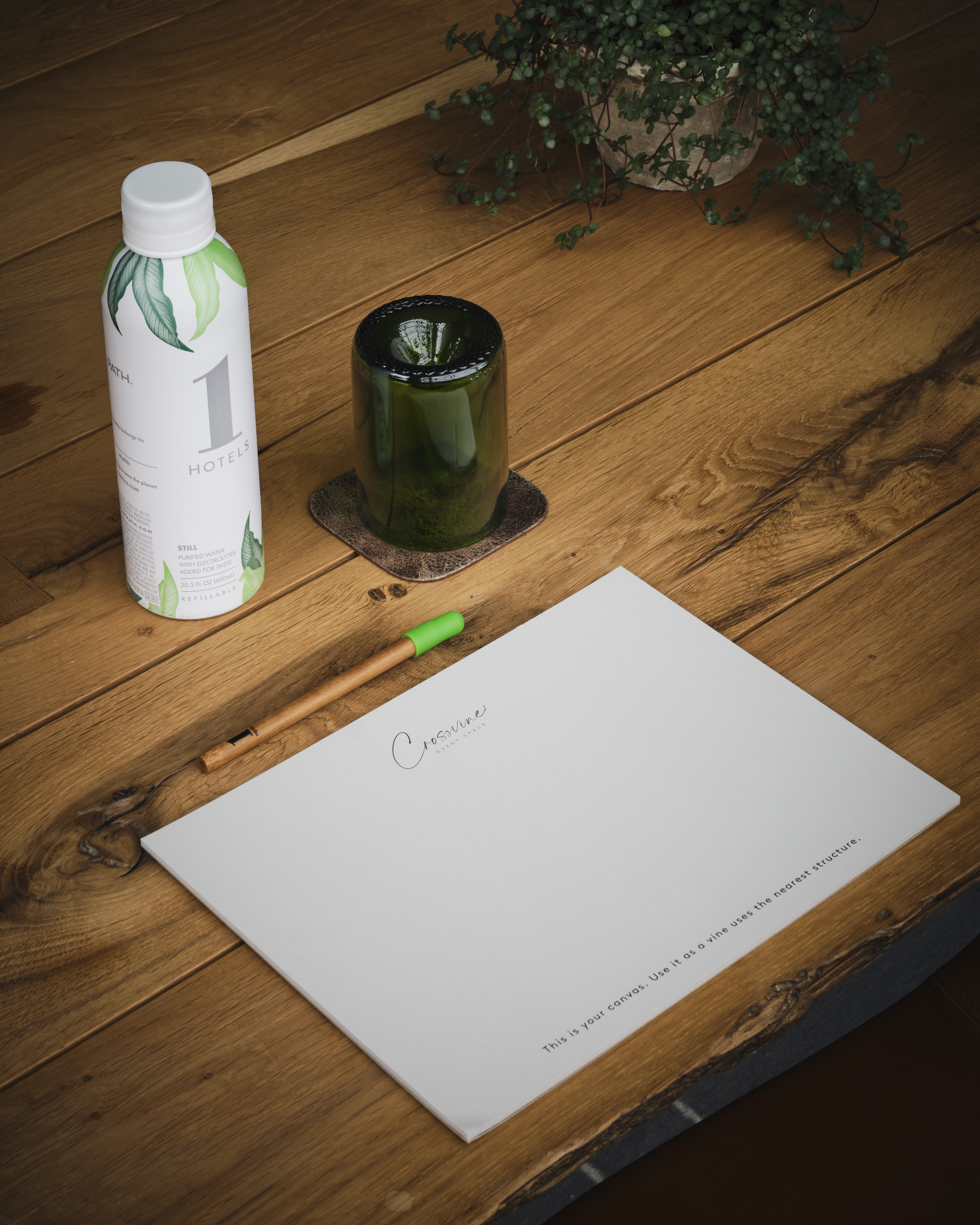 a water bottle, paper, and a pen on a table