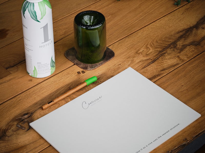 a water bottle, paper, and a pen on a table