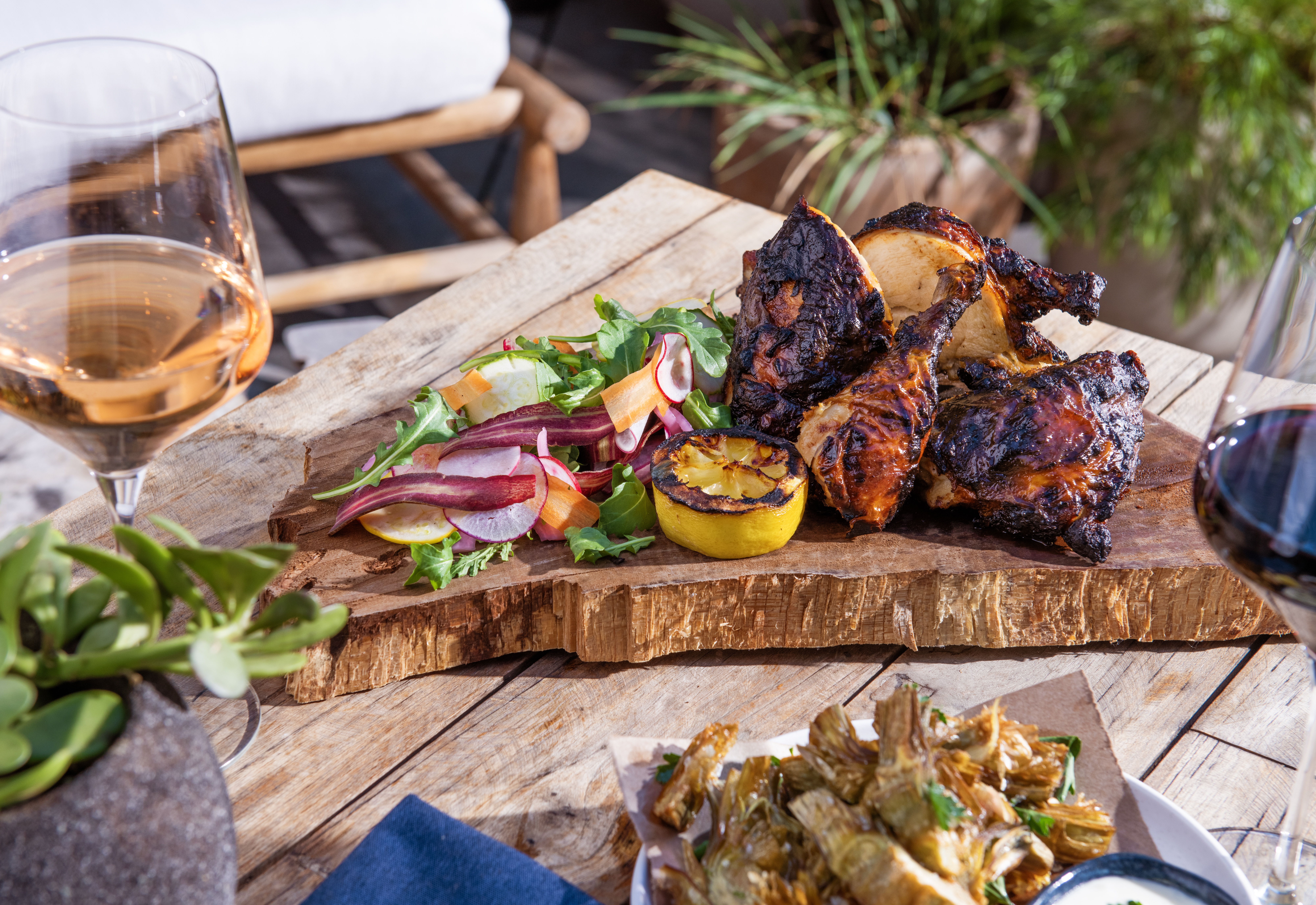 Chili marinated half chicken on a wood slab