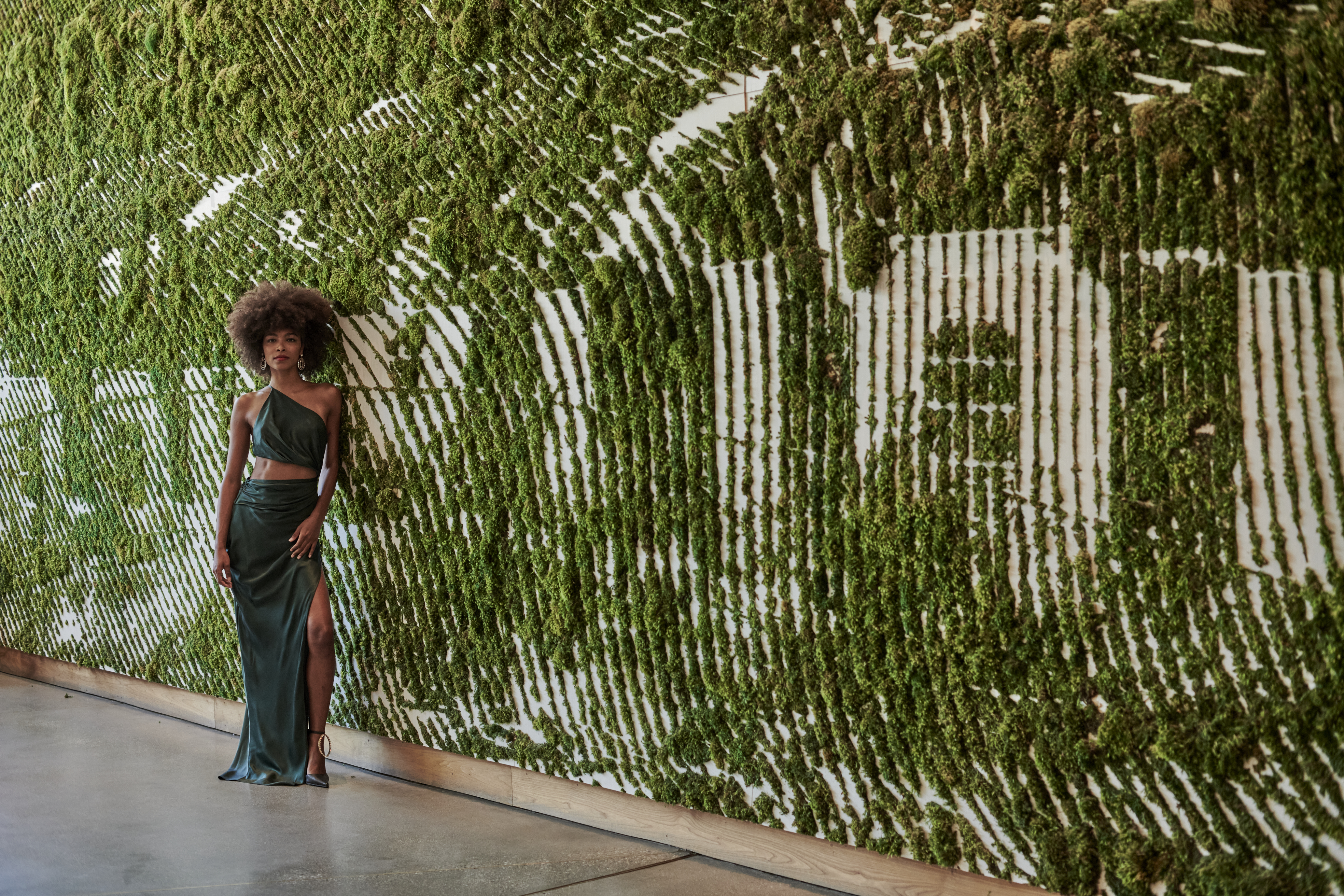 Woman stand in front of the 1Hotel West Hollywood plant sign 