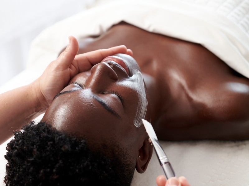 A woman at the spa getting a facial mask