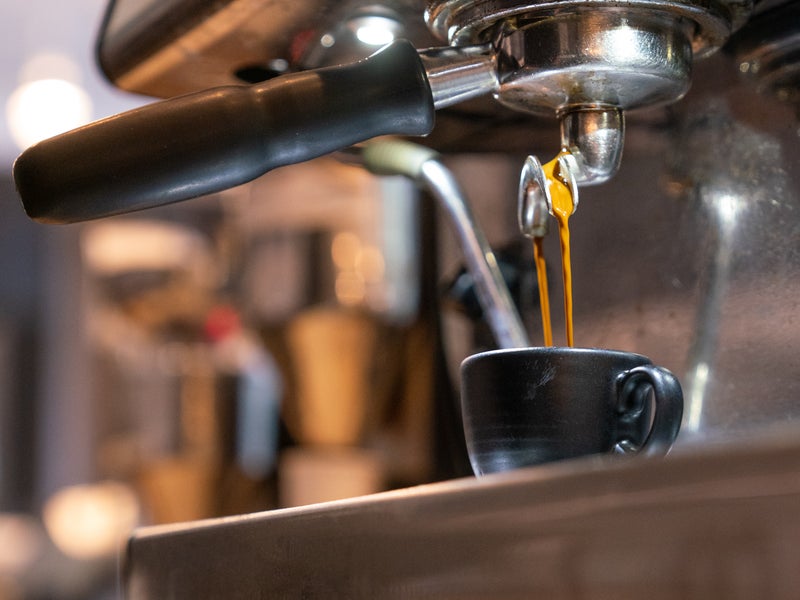 An up close shot of espresso being poured from an espresso machine