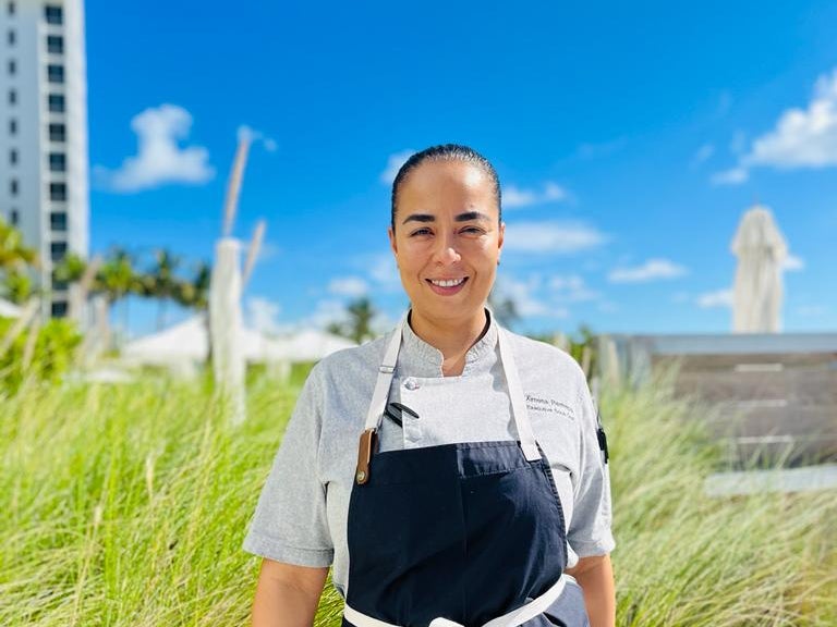 Chef posing for a photo in front of tall grass
