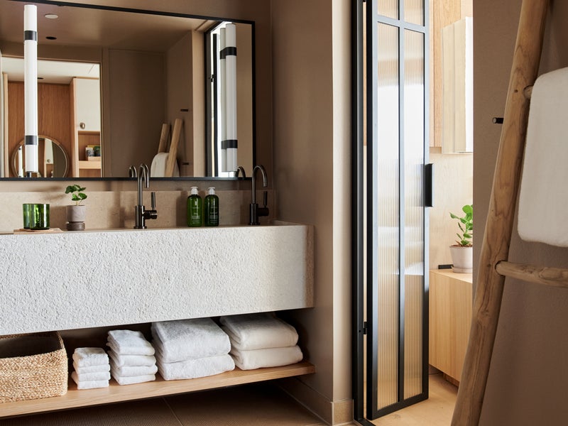 A large bathroom mirror in a room stocked with towels