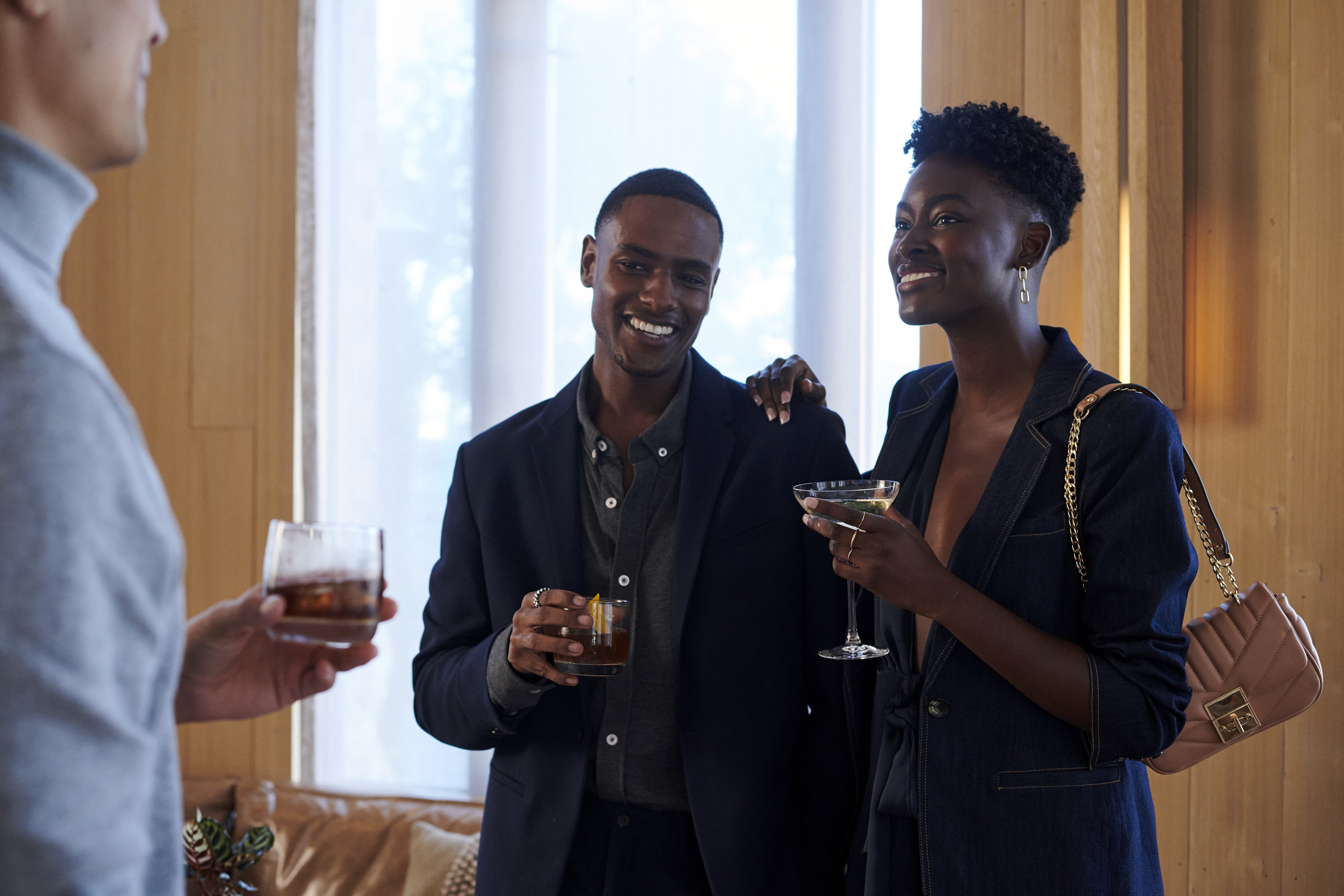 People holding a drink and laughing