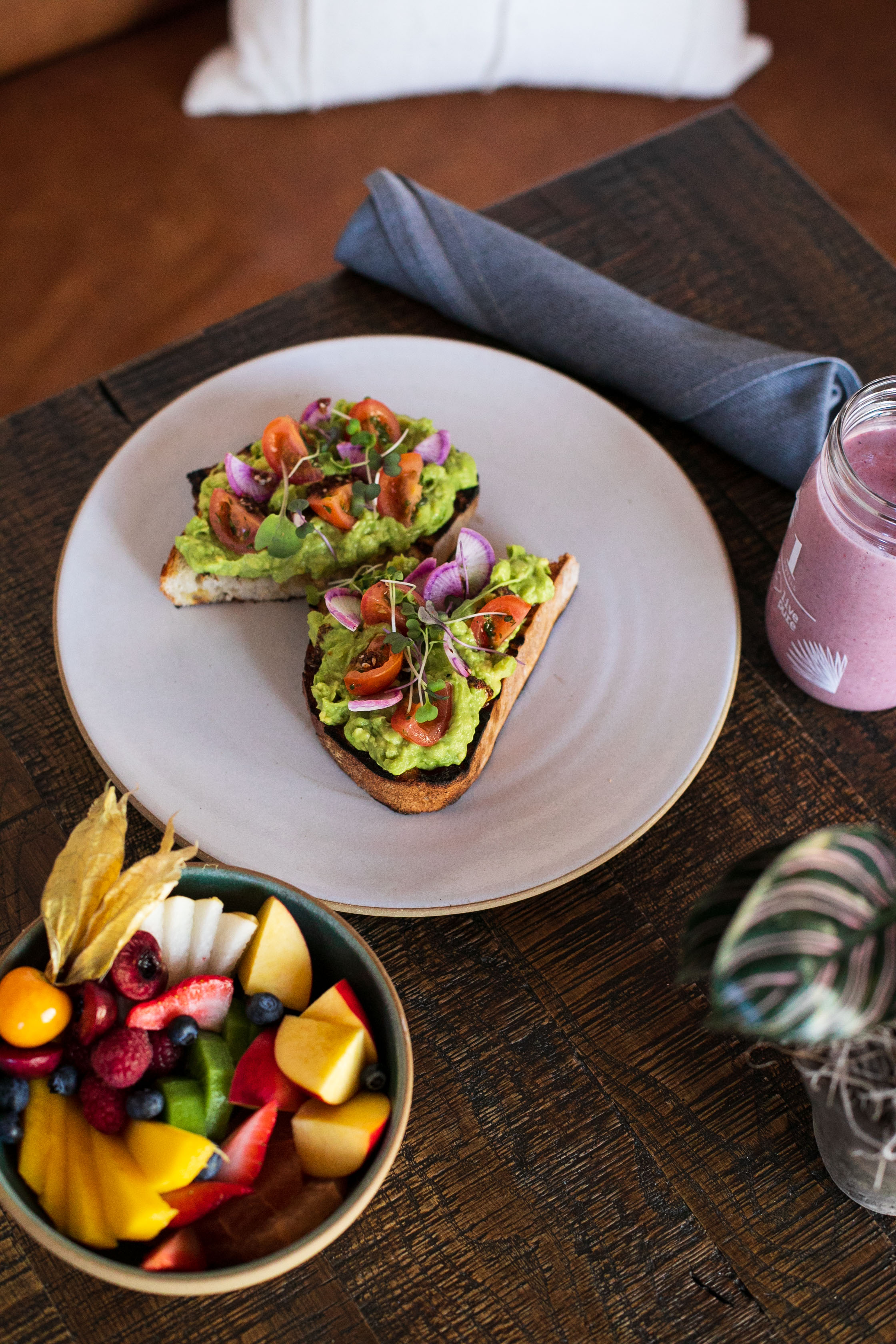 Sandwich à l'avocat avec un bol de fruits et un smoothie