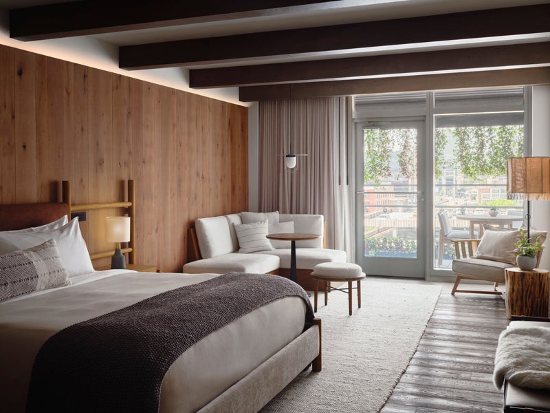 Bedroom with a large king size bed, seating area, and doors which lead out onto a patio