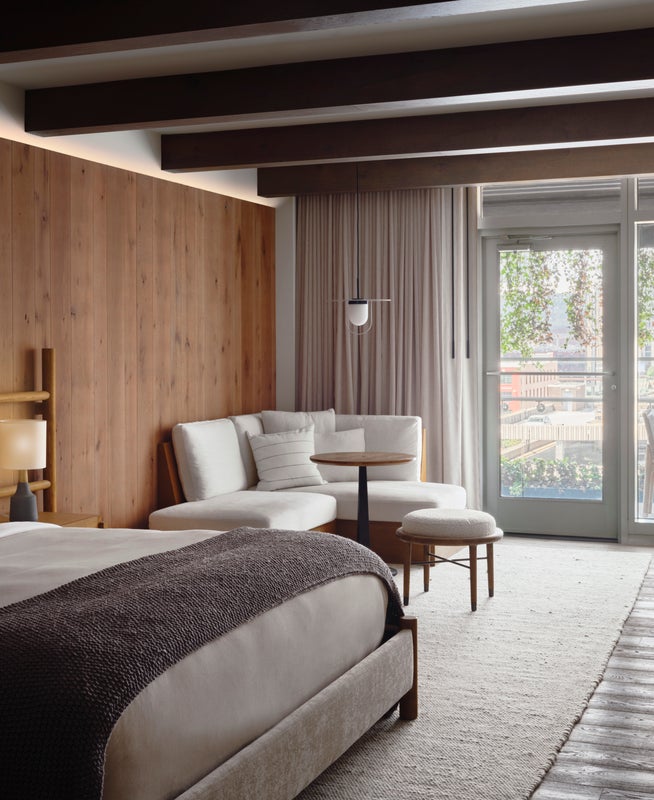 Bedroom with a large king size bed, seating area, and doors which lead out onto a patio