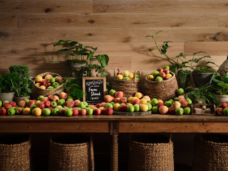 Table filled with green, yellow and red apples