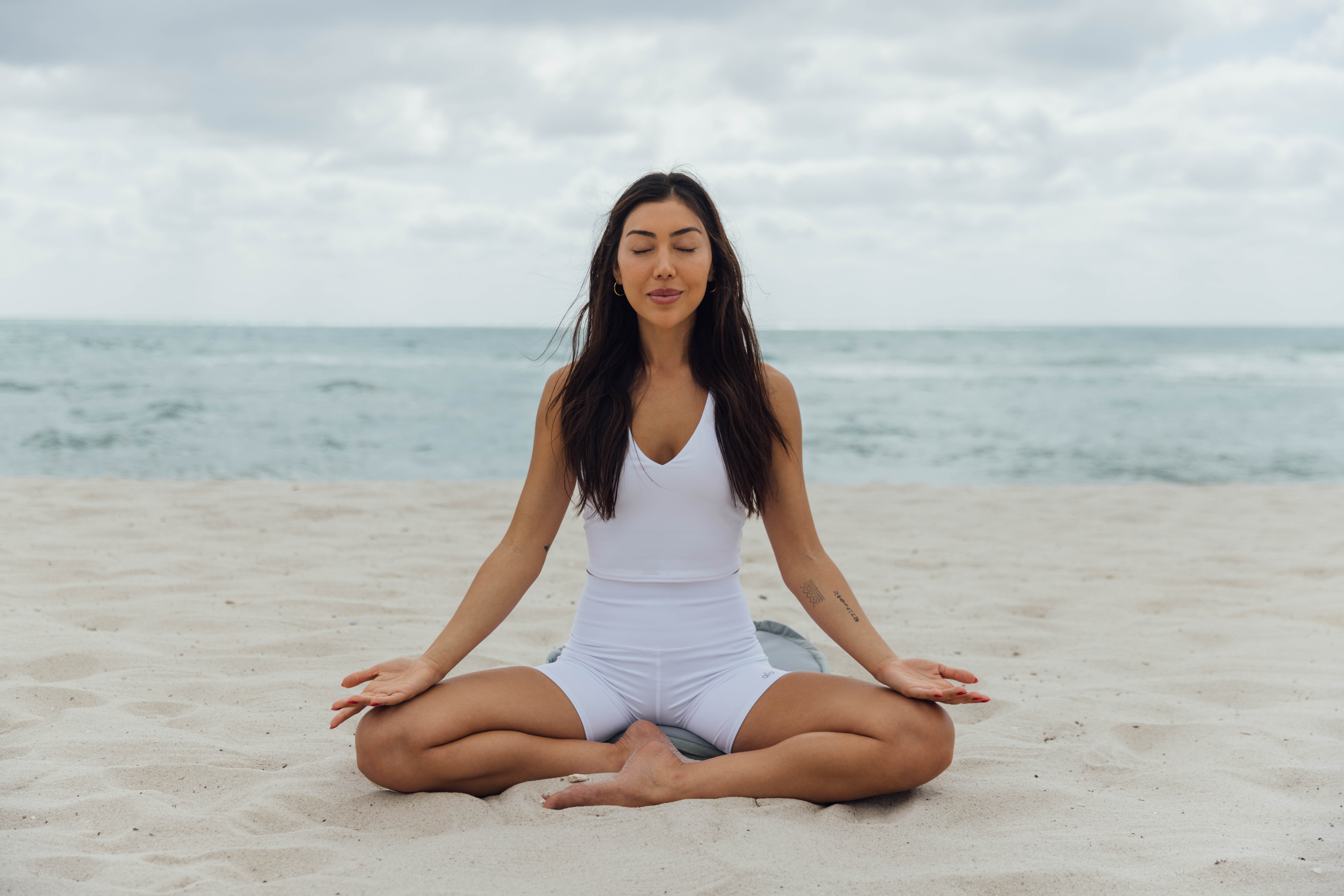 A woman meditating on the beach