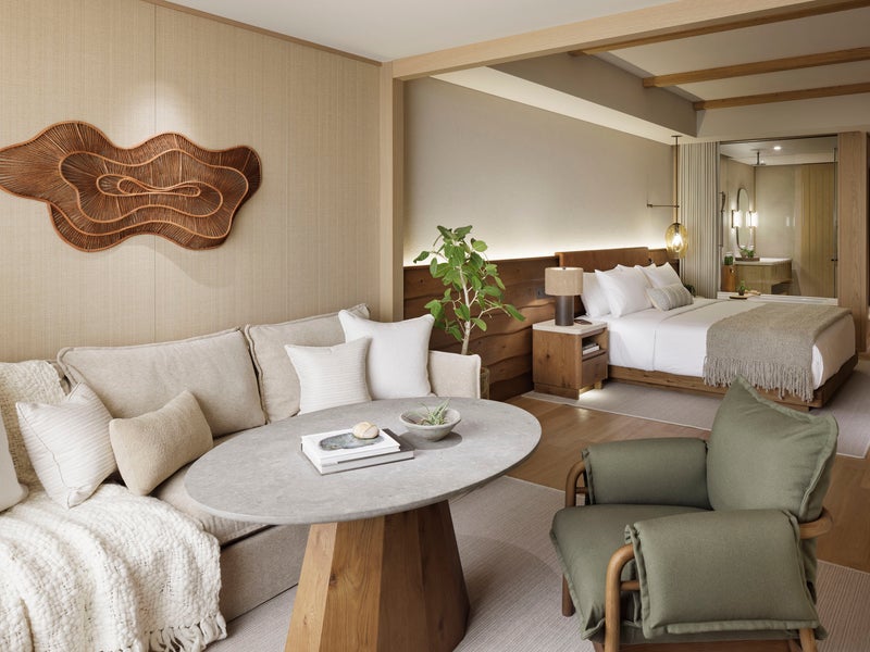 Warm-toned large room with bed, couch, and bathroom