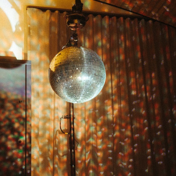 An illuminated disco ball hanging from a pole