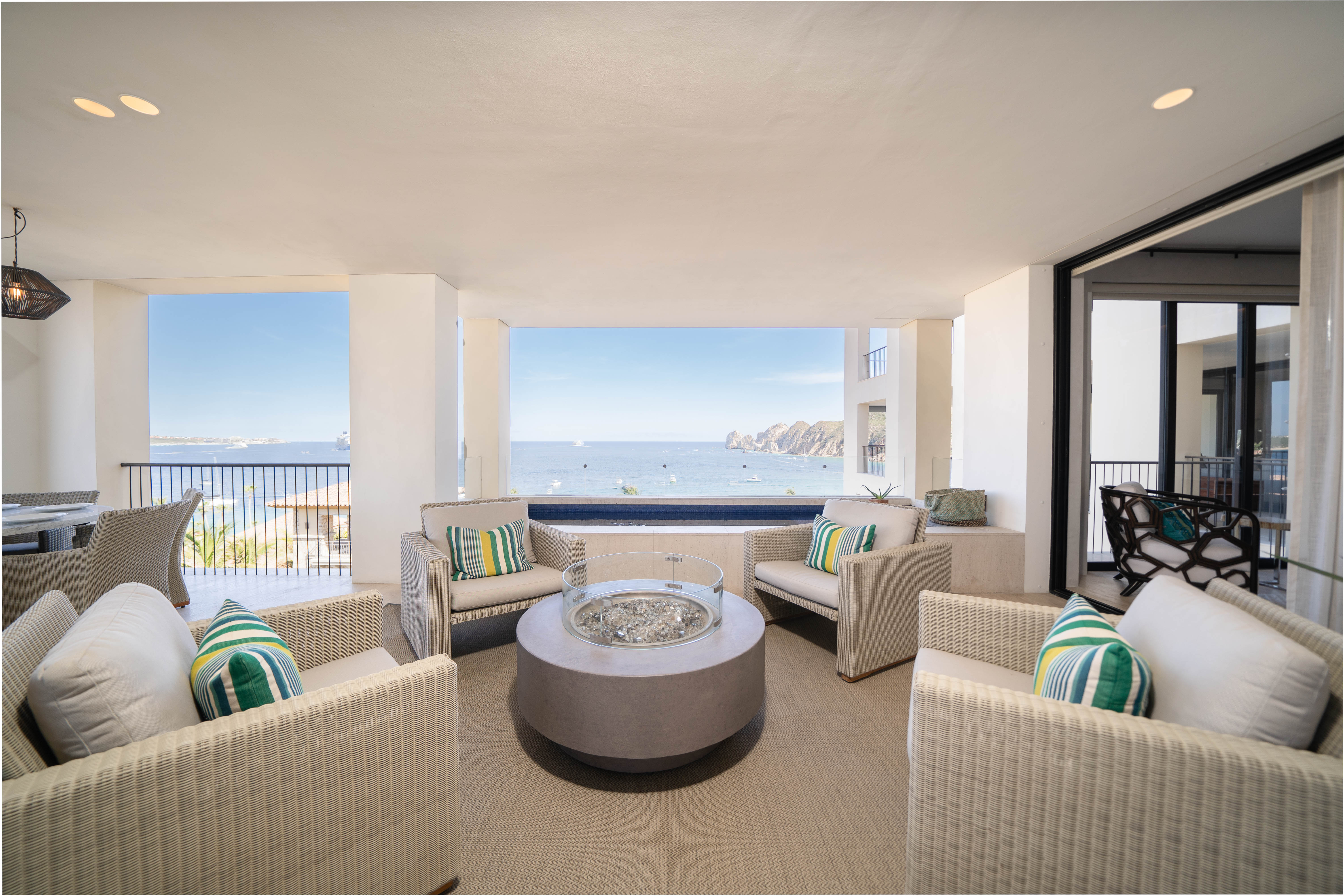 Covered balcony with lounge chairs surrounding a firepit