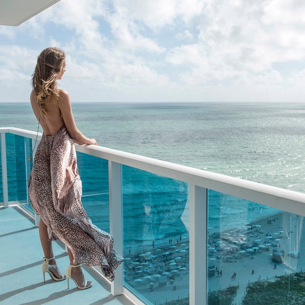 Person standing on a balcony looking out to the ocean