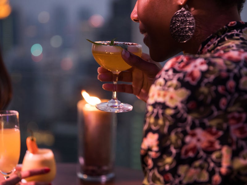 Person sipping a cocktail at night