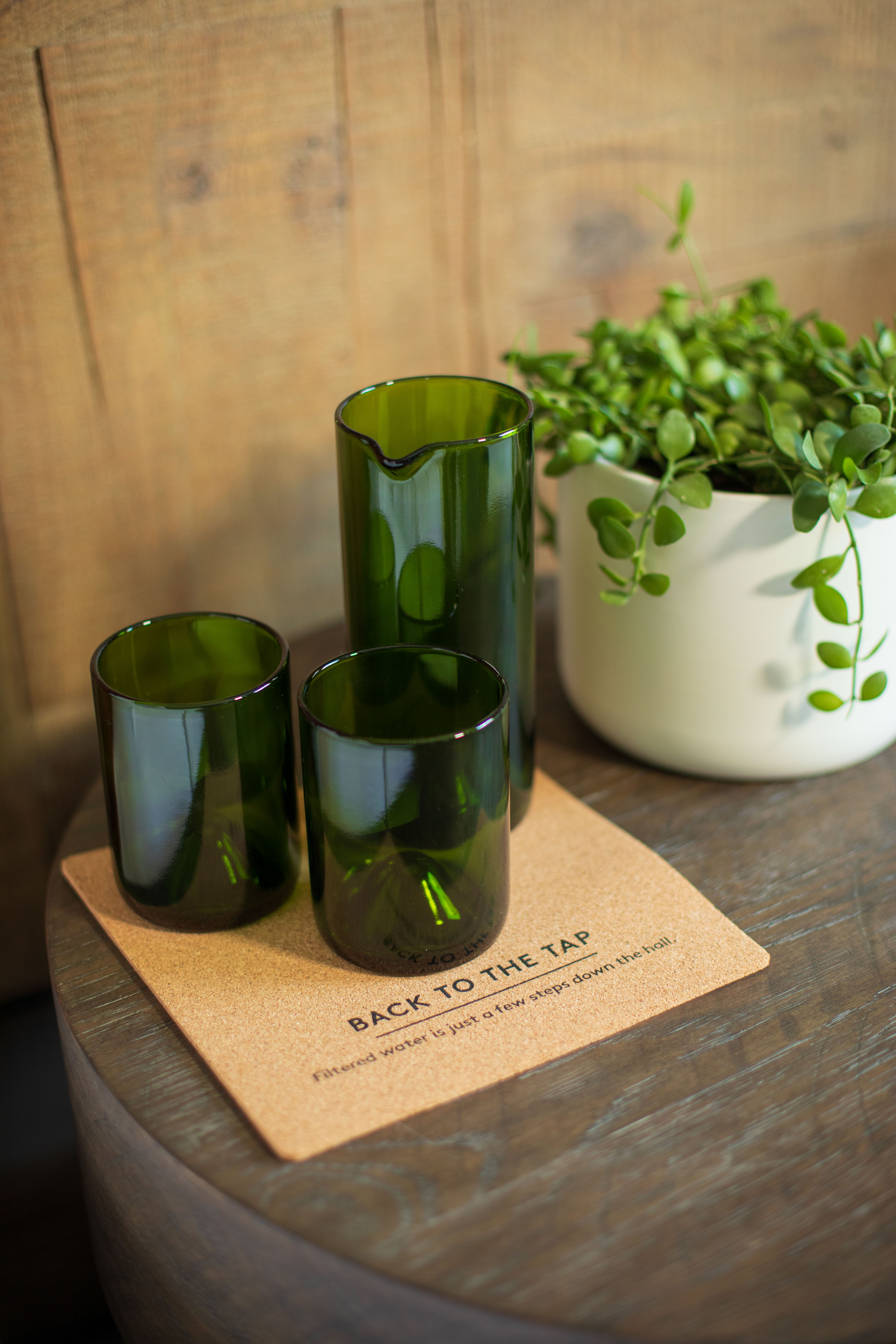 Three green glasses on a cork coaster