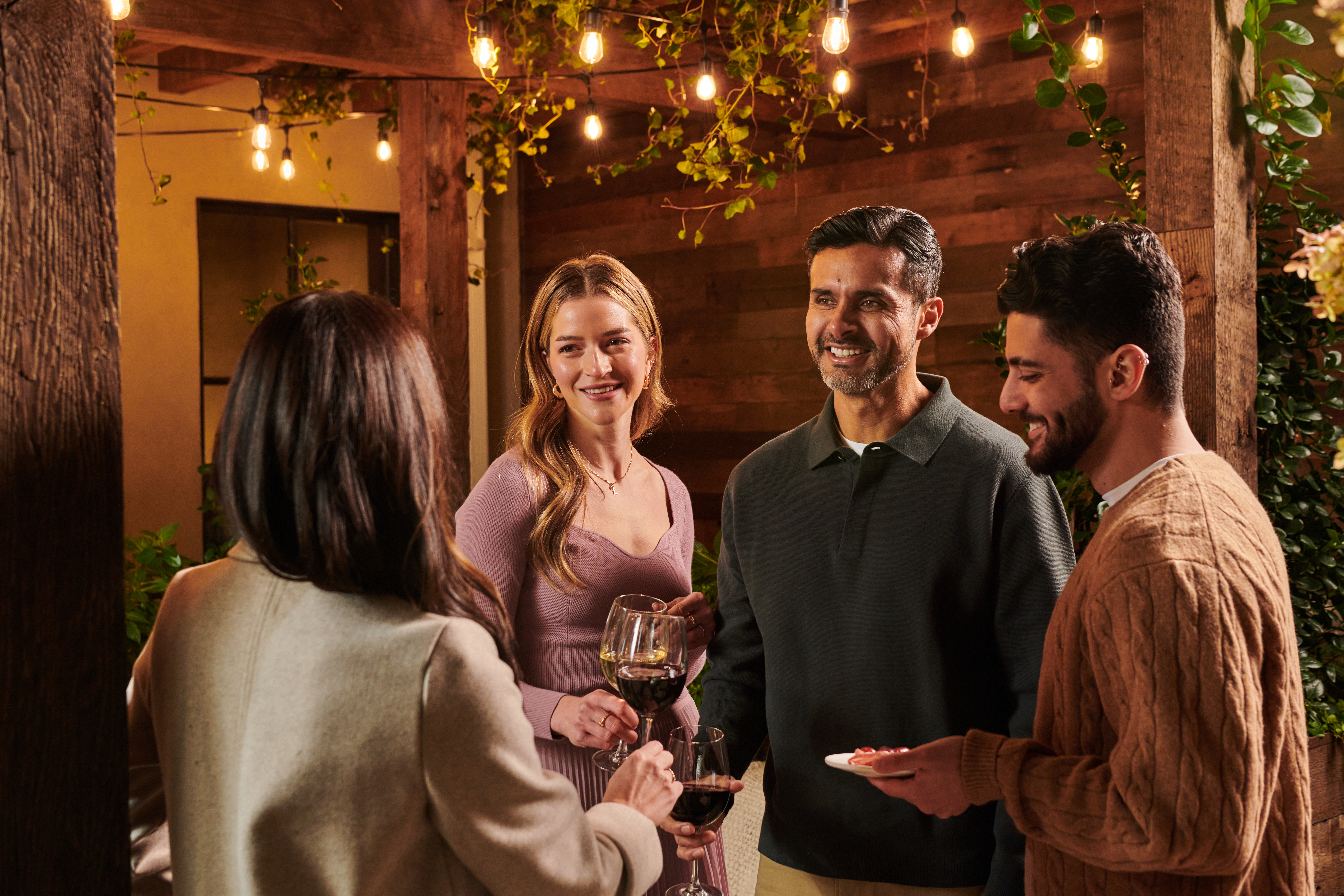 a group of people talking and drinking wine