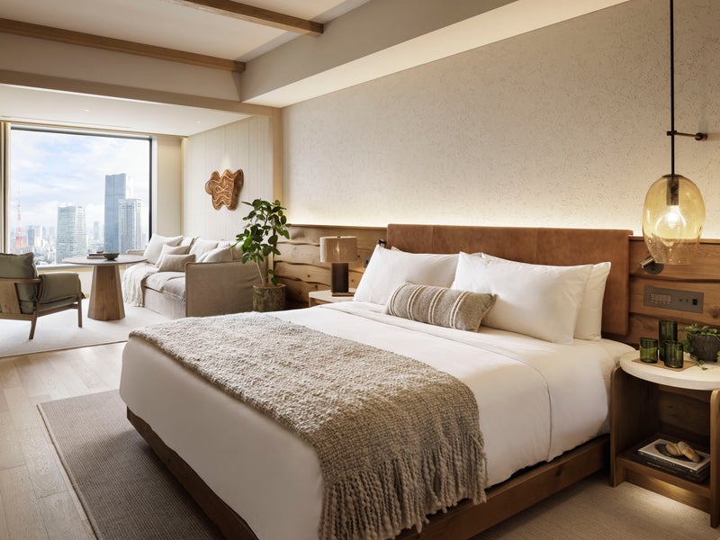 A king bed, A table and chairs with unique lightbulb in a large bedroom