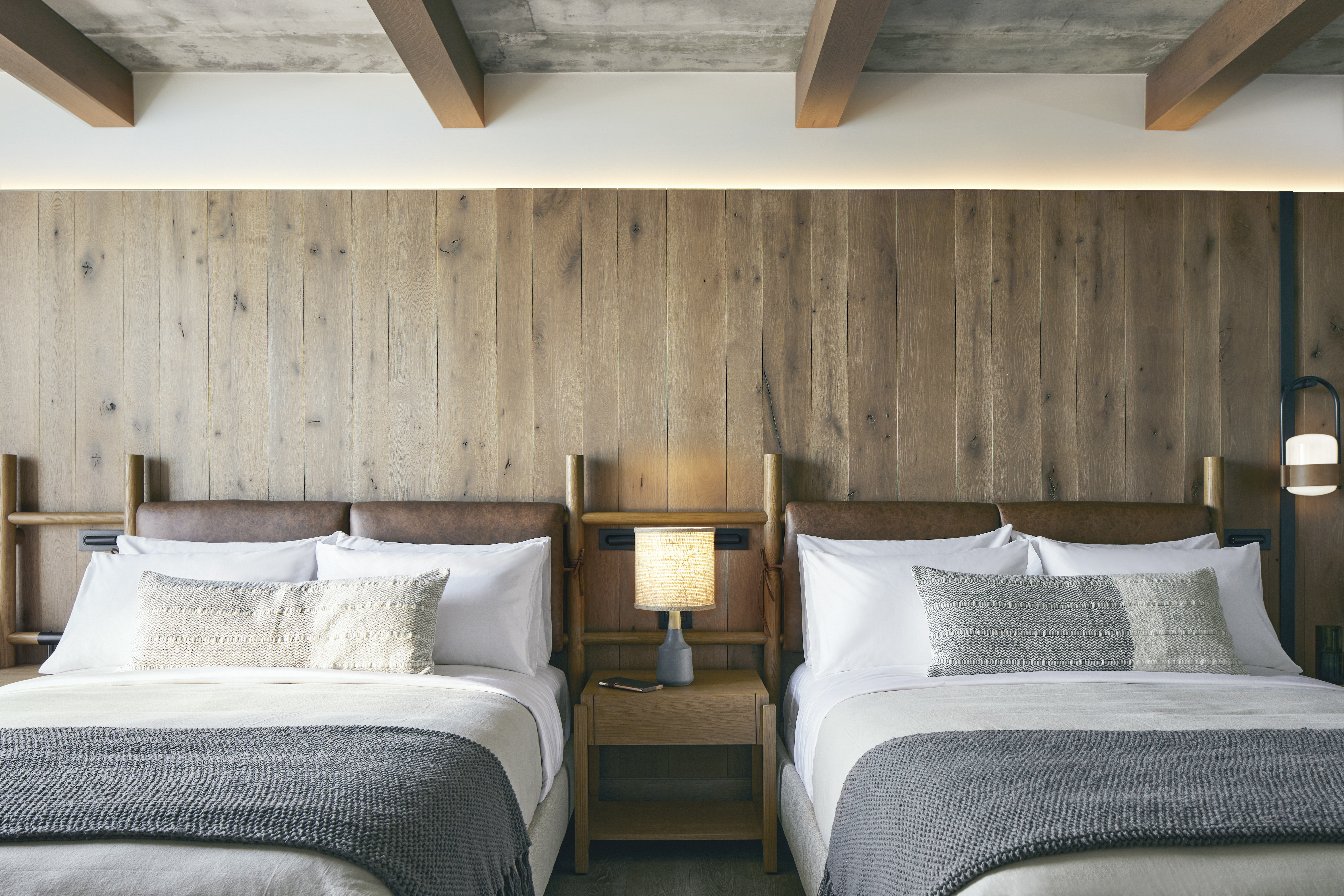 Two double beds with wooden headboards sit side by side