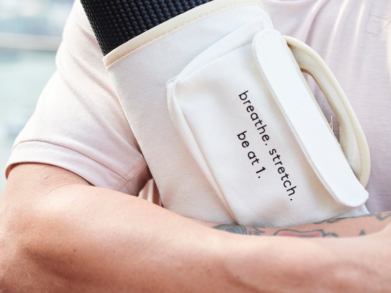 Person holding yoga matt