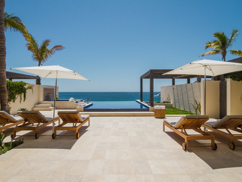 Outdoor patio with reclining lounge chairs overlook a view of the ocean