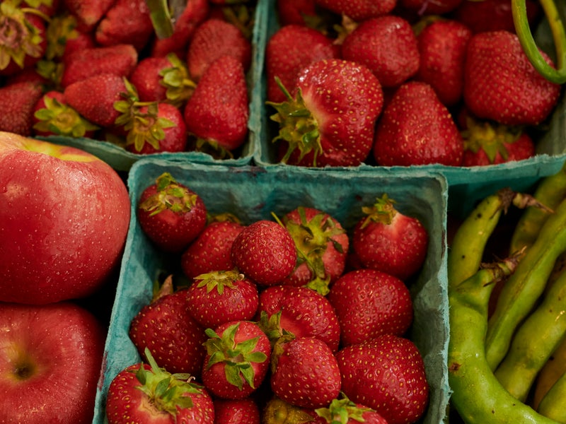 Baskets of strawberries, apples, rhubarb and peas