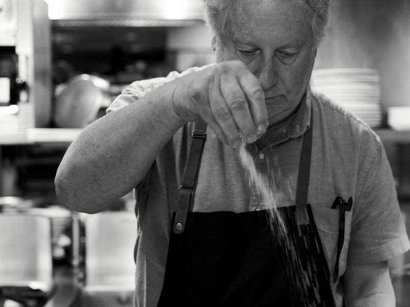 Chef Jonathan Waxman adds finishing touches to a dish