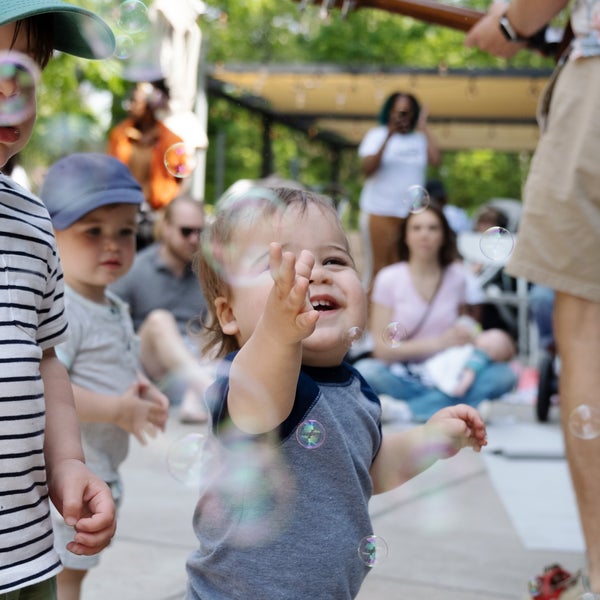 a child laughing and playing with bubbles