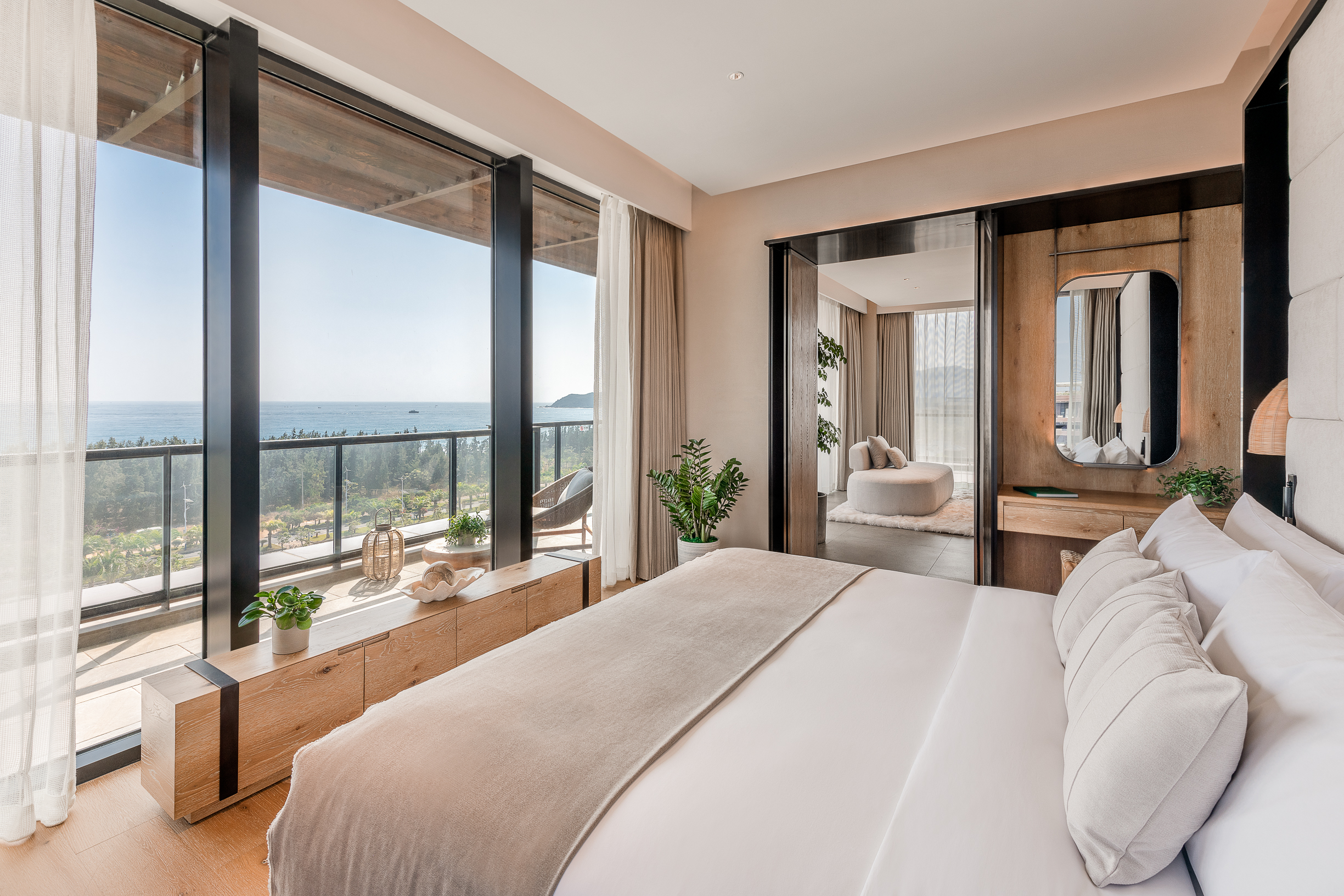 A bed facing the window which looks out to the ocean