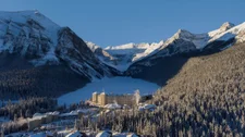 Snow-capped mountains and lake with hotel in the middle