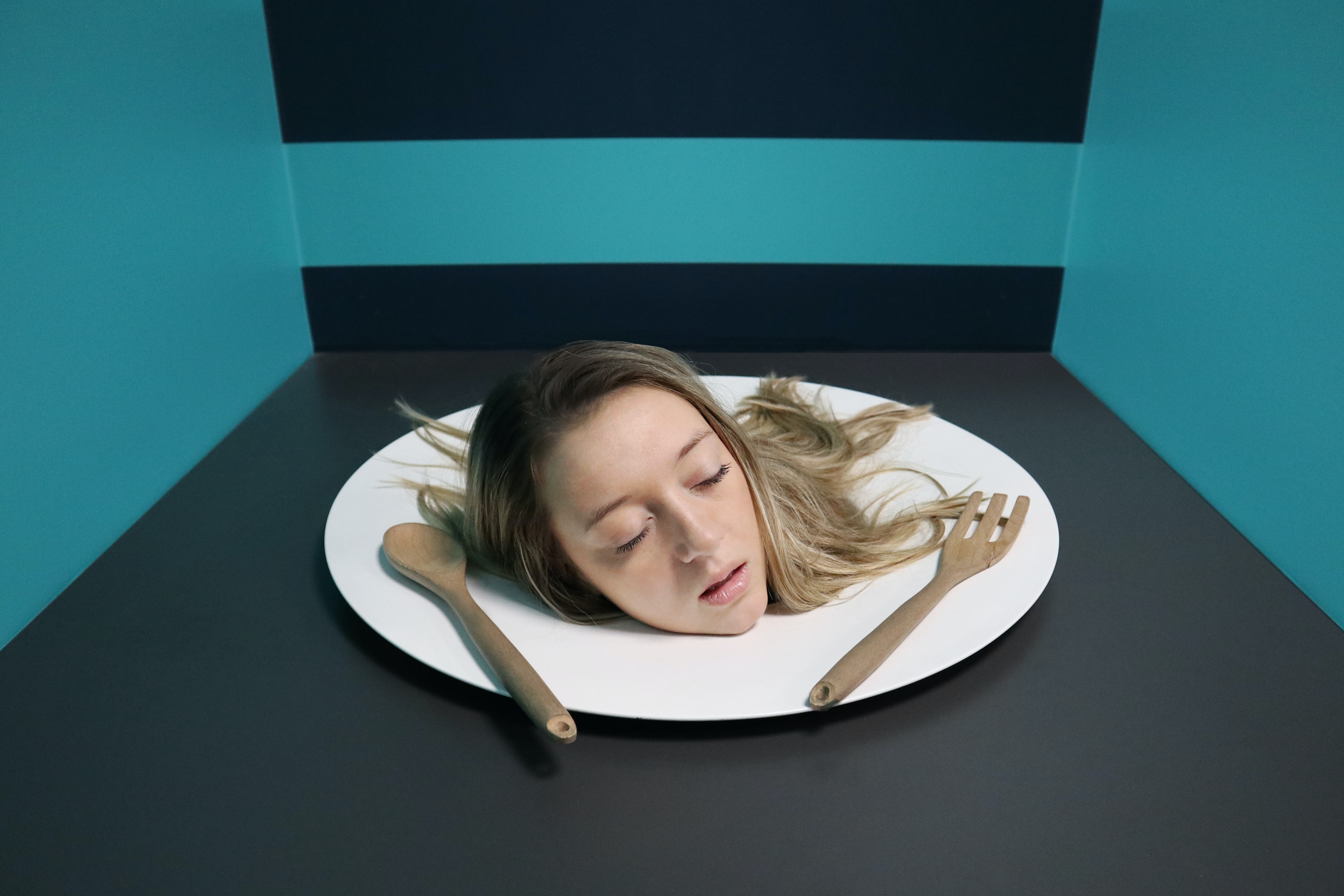 A woman's head on a plate illusion in a museum