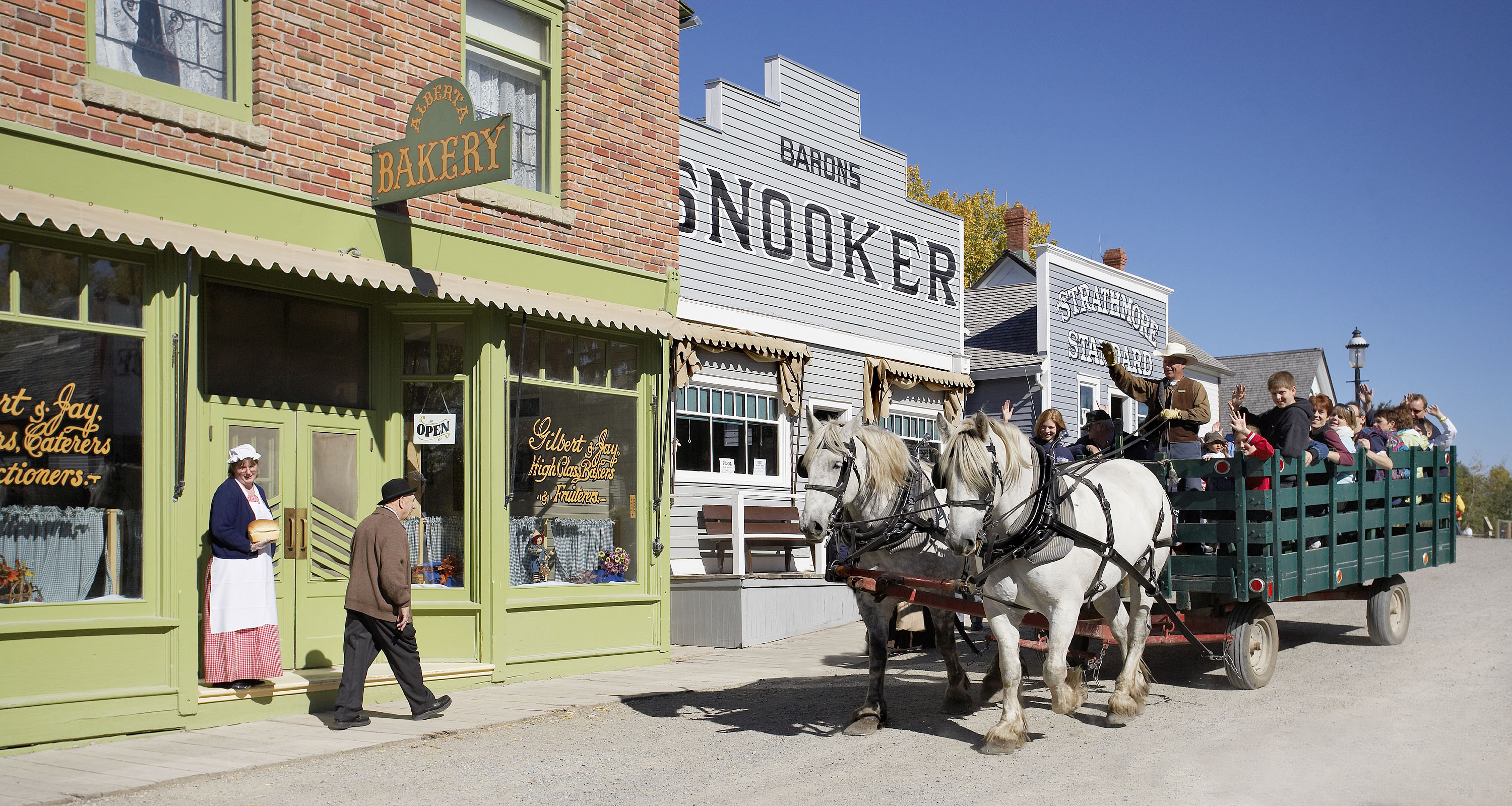 Horse and wagon take visitors past heritage buildings in Calgary’s Heritage Park Historical Village