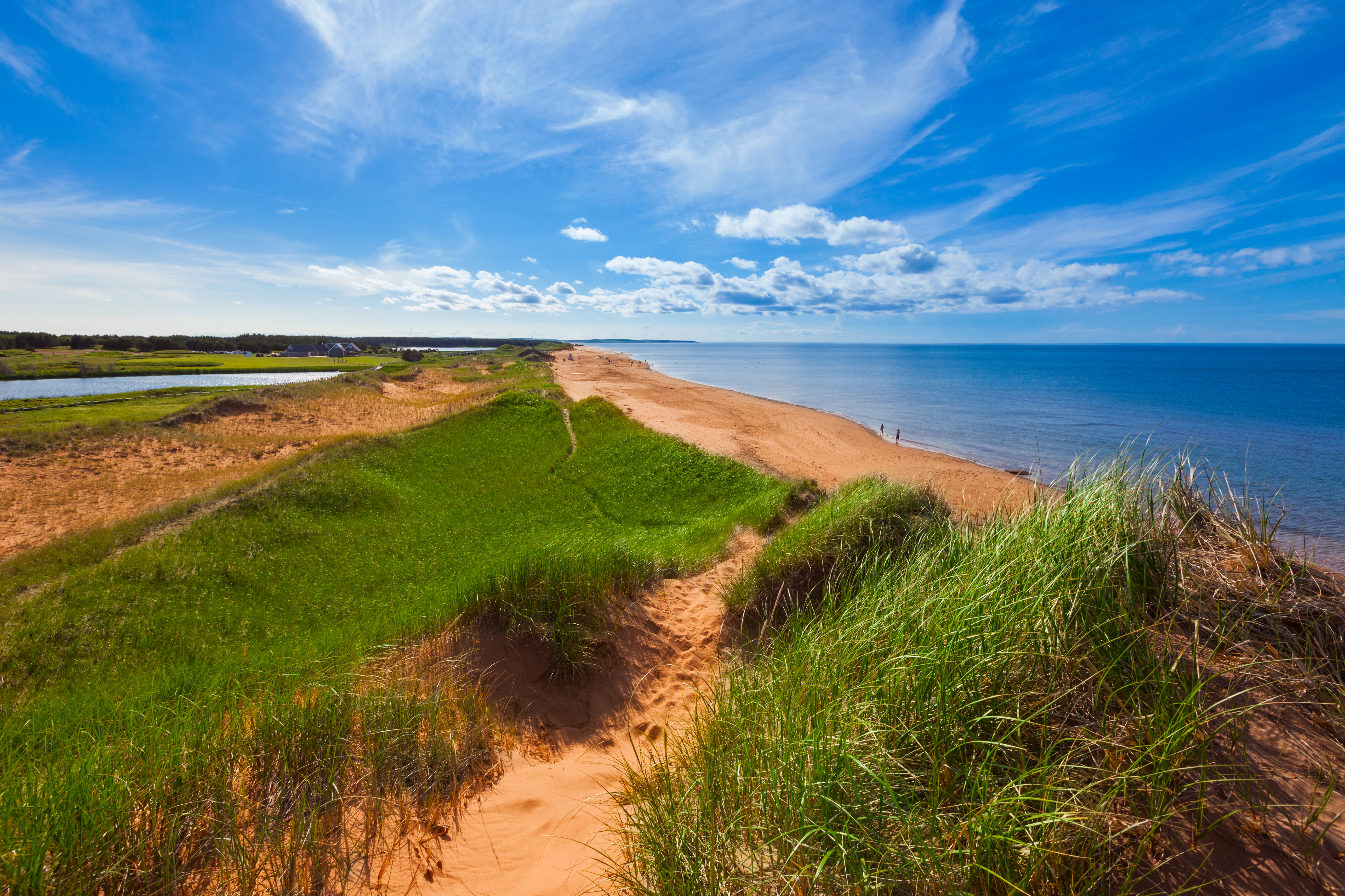 Red sandy beach and sand dunes at Prince Edward Island National Park with blue sky above
