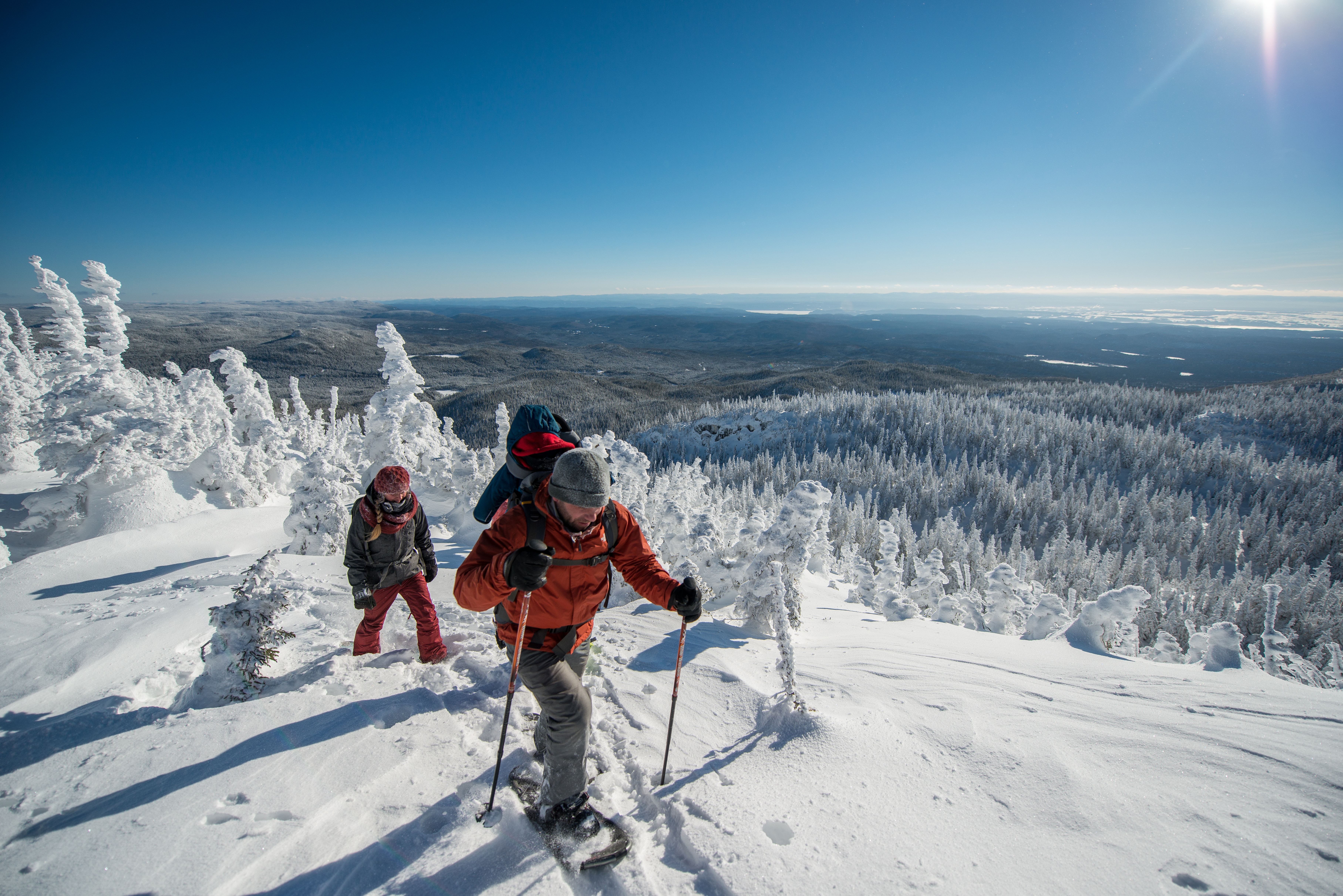 A family snowshoeing in the mountains in Quebec on a clear day