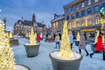 People walk through Place Jacques-Cartier during a winter evening 