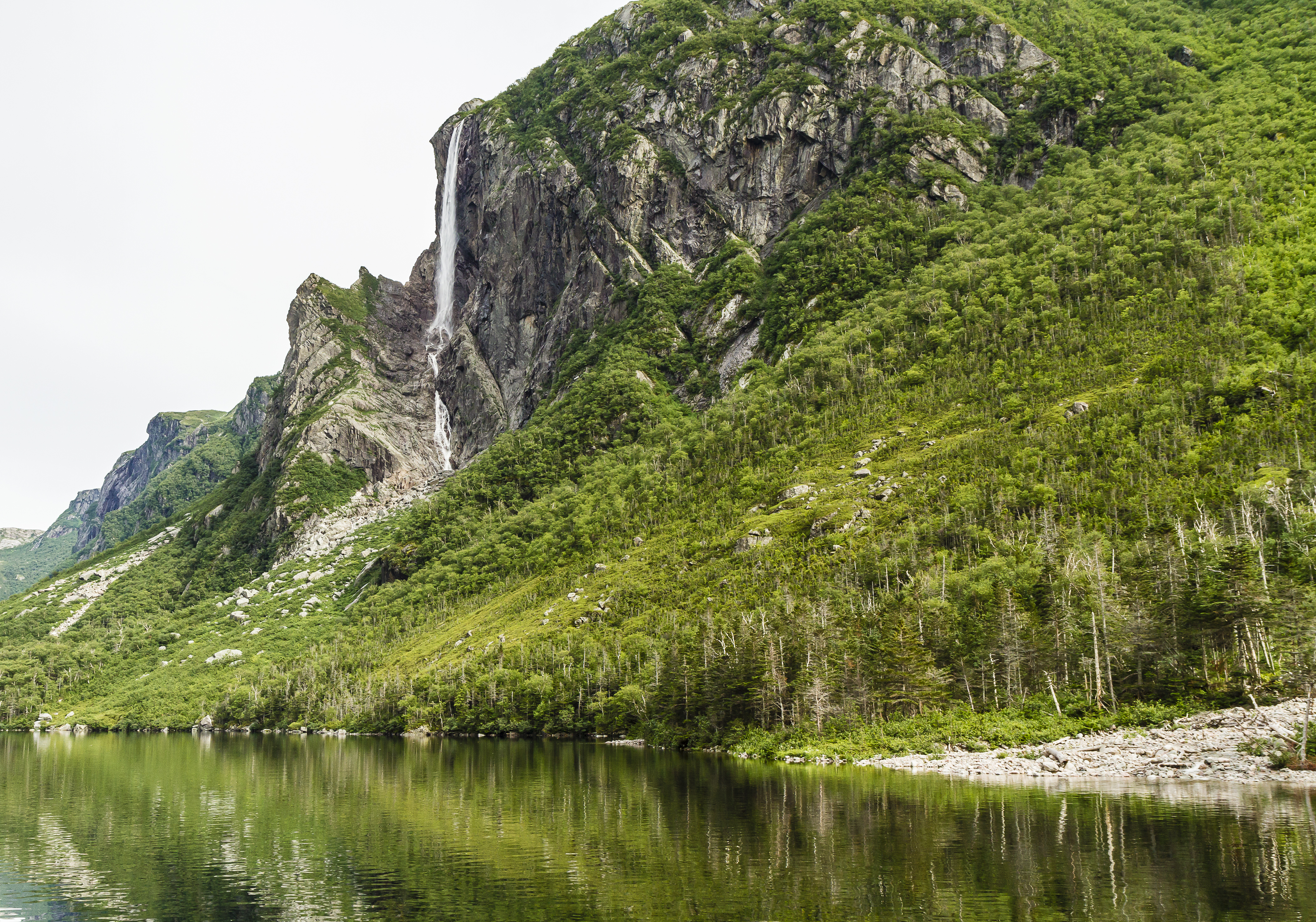 View of waterfall cascading down a lush, rocky cliffside
