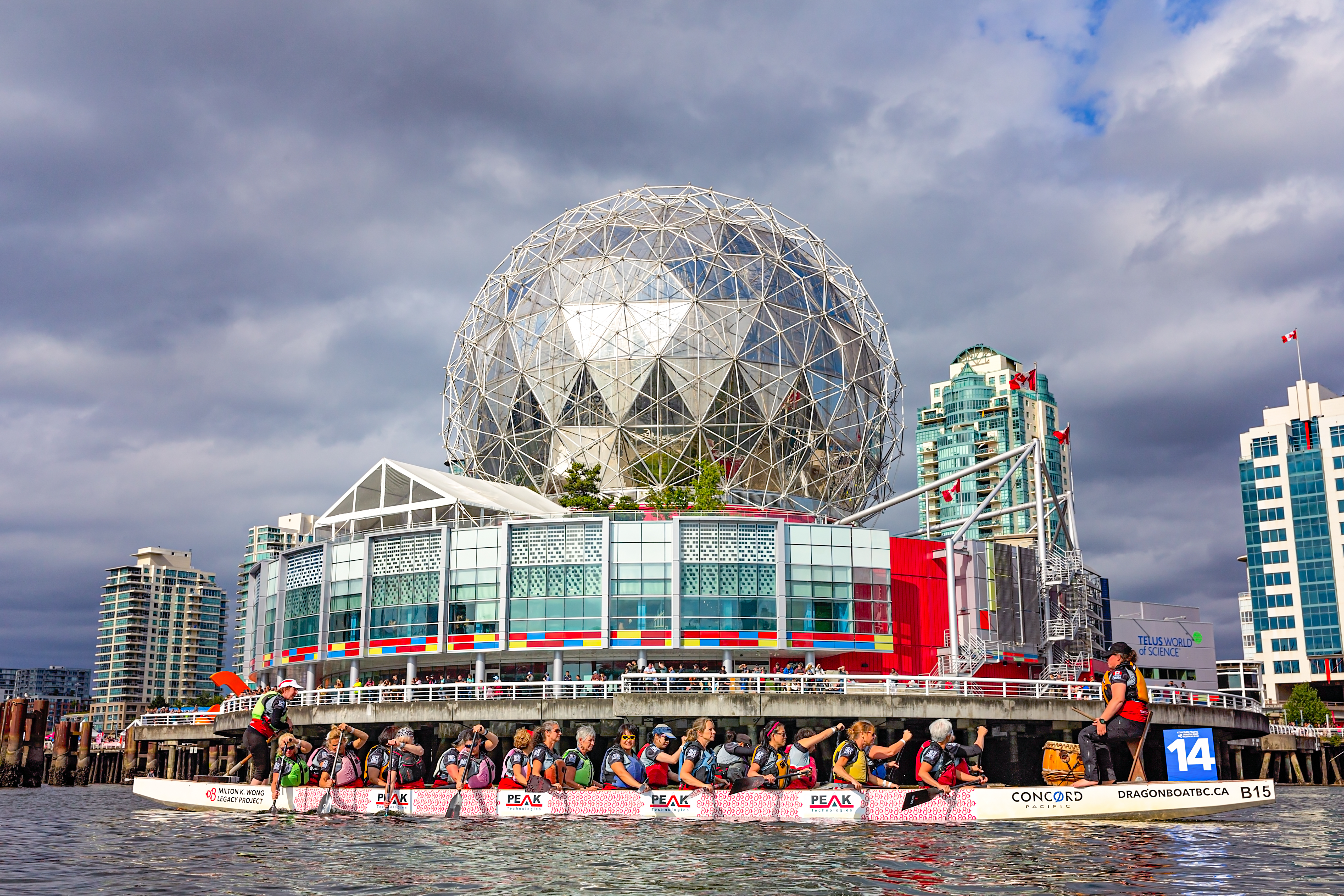 Dragon boat racing team paddle in front of Science World in False Creek