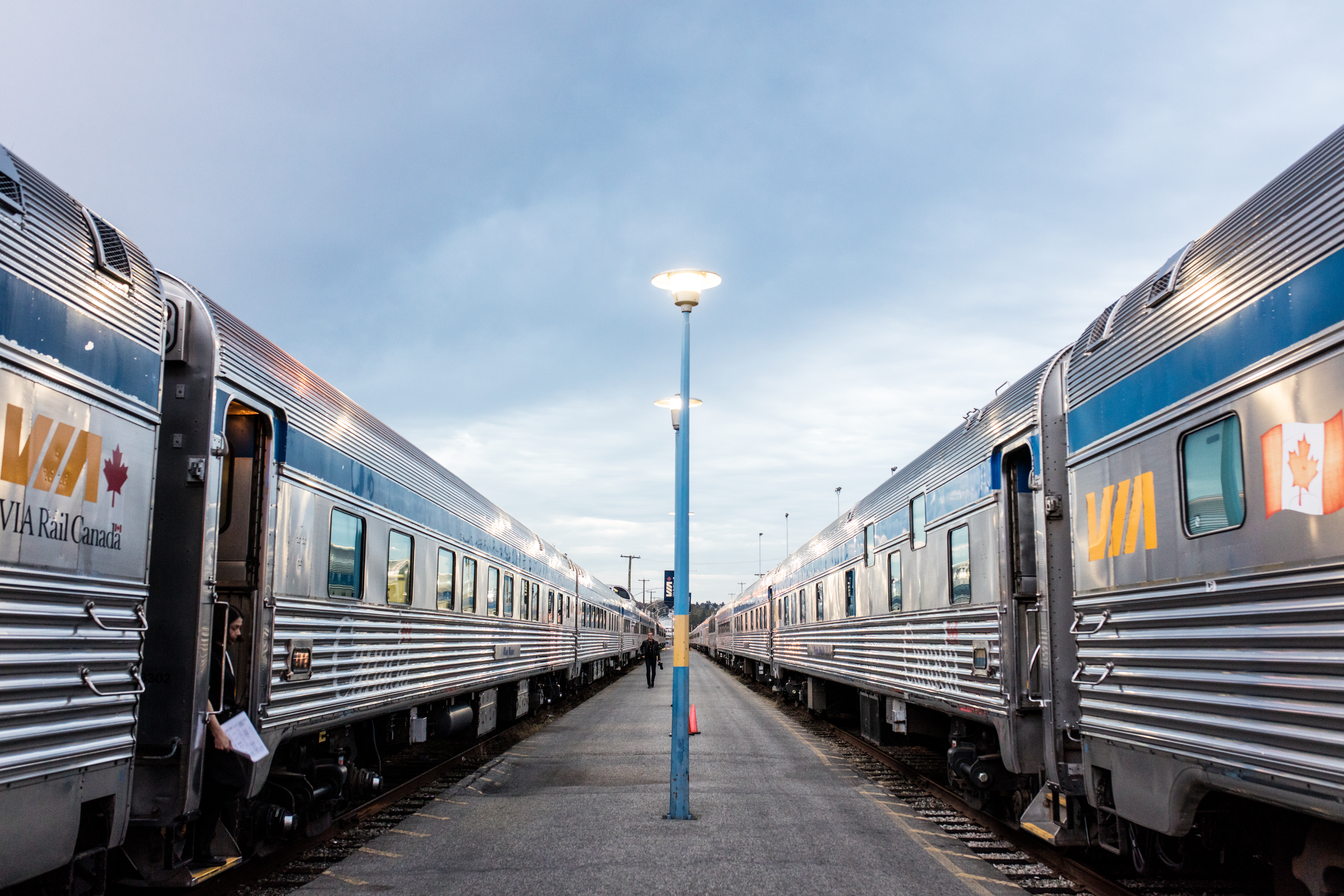 View of two VIA Rail train stations parked at the train station with platform in between
