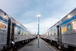 View of two VIA Rail trains sitting on a train station platform