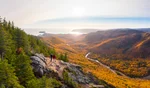 Two hikers enjoy the autumn colours in Cape Breton, Nova Scotia