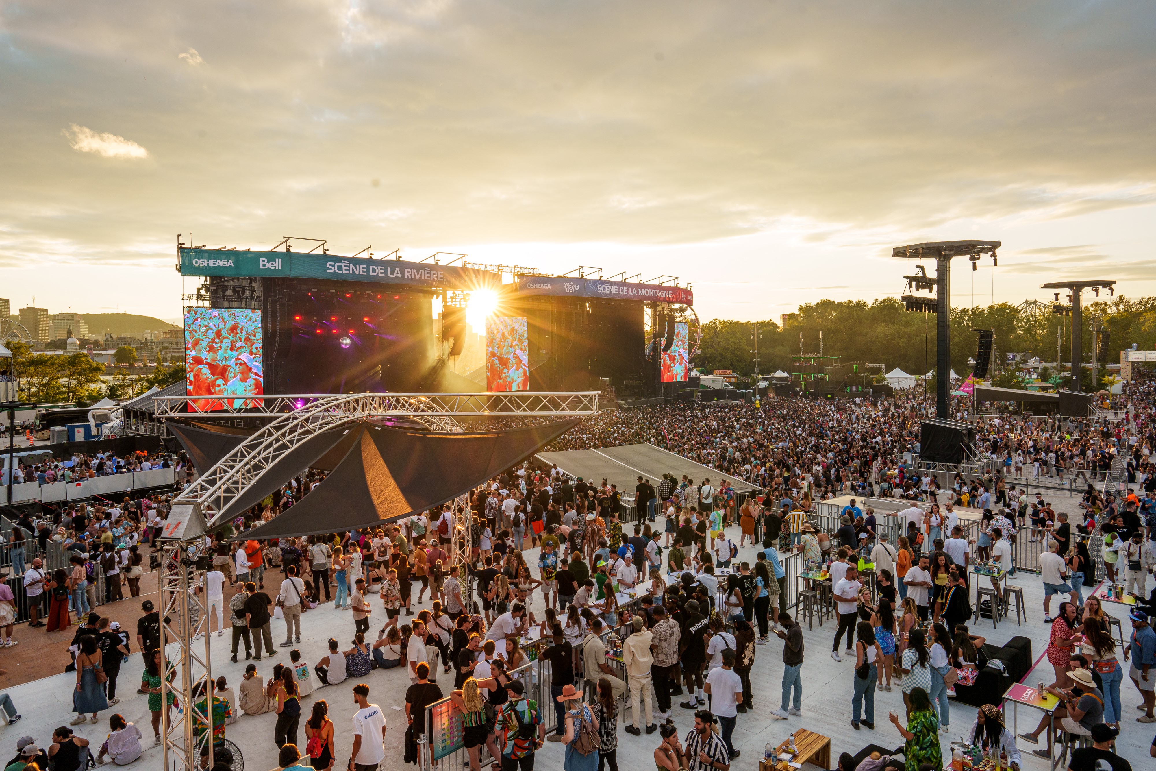Crowd in front of the Osheaga festival stage as the sun sets behind