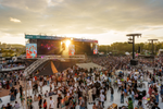 Crowd in front of the Osheaga festival stage as the sun sets behind