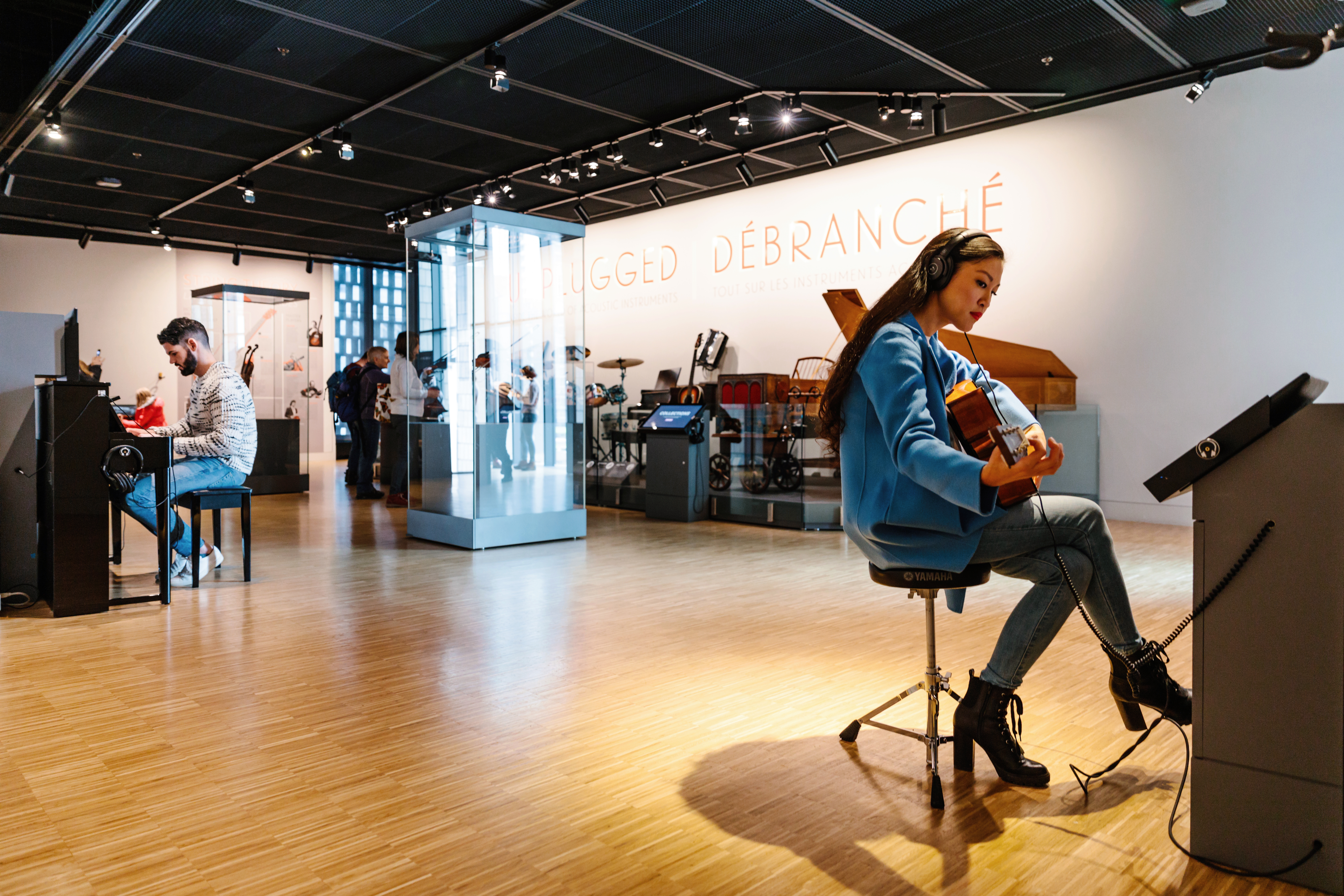 Visitors playing instruments in a music room at Studio Bell